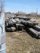 Squared timber from the dismantled Regan House, lies unprotected in a public works yard. Three years after the historic log home was dismantled, there is still no plan for its reassembly. Photo Colin Mckim